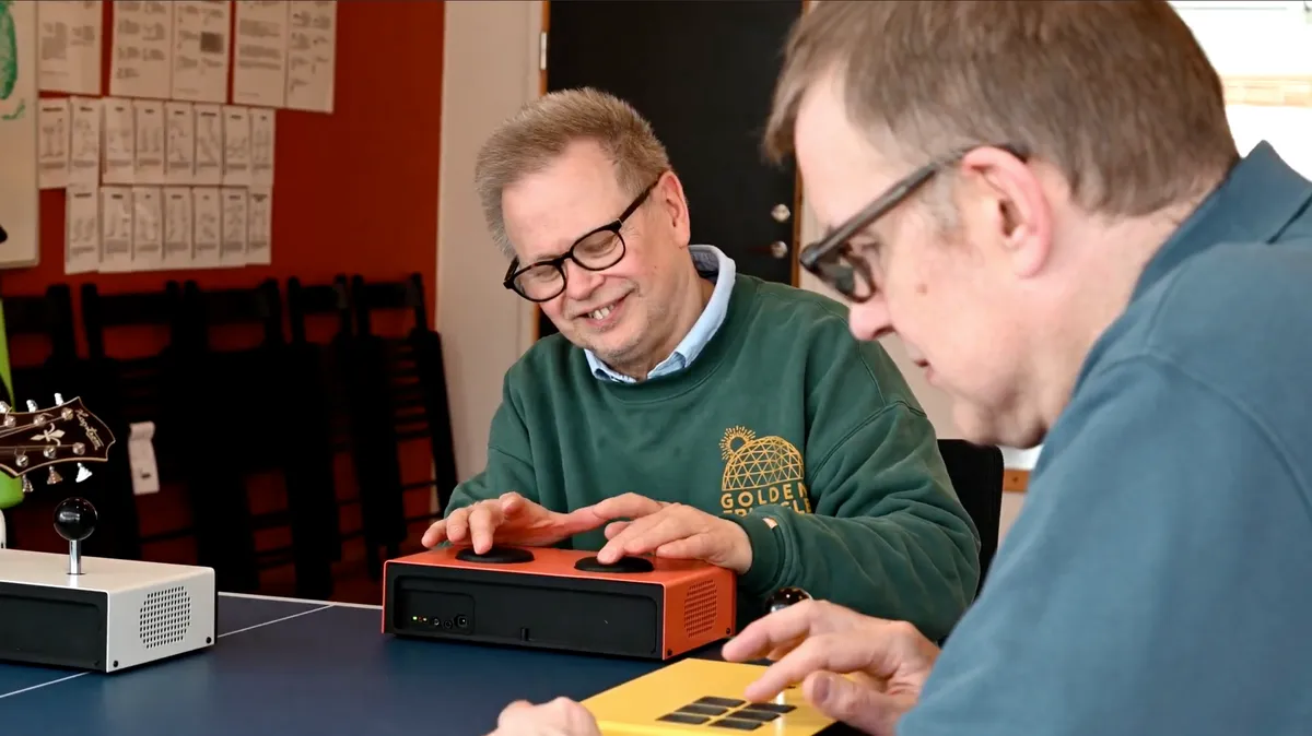 Två män spelar tillsammans på Funki-instrument vid ett bord