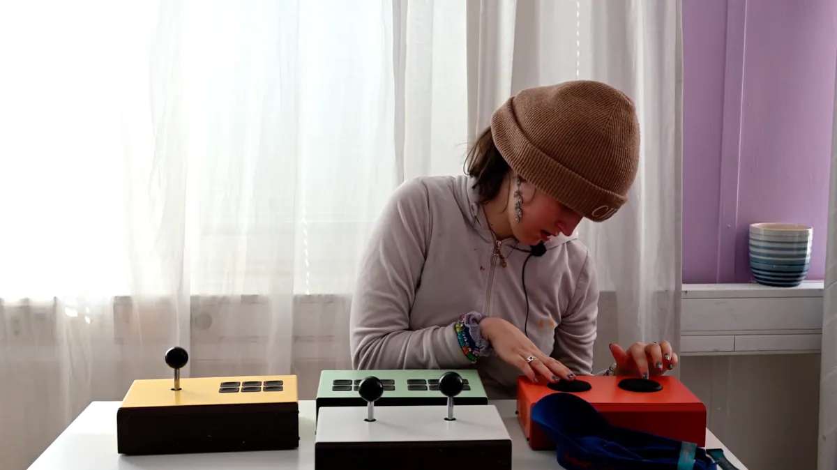 Ung kvinna spelar på Funki-instrument med spakar